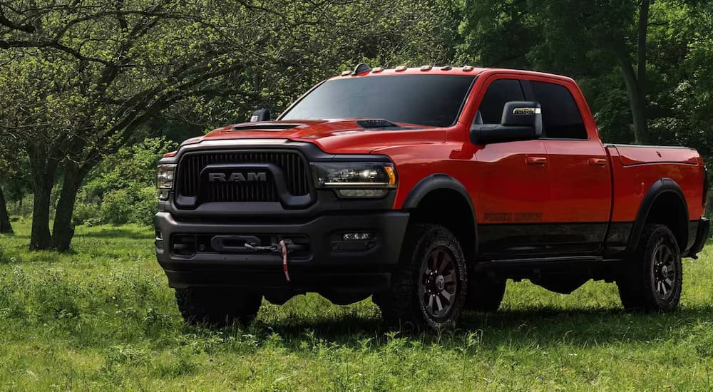 A red 2024 Ram 2500 Power Wagon parked in a grassy field.