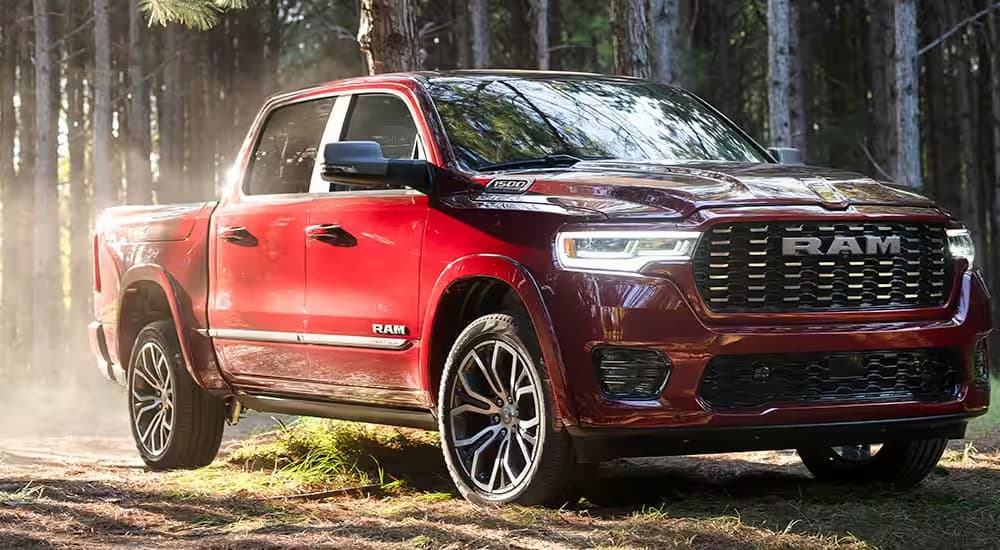 A red 2025 Ram 1500 Tungsten parked in the woods.