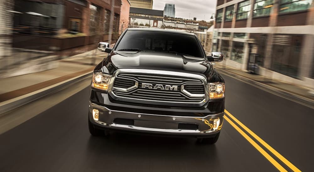 Head-on view of a black 2018 Ram 1500 driving to a Ram dealer near Newark.