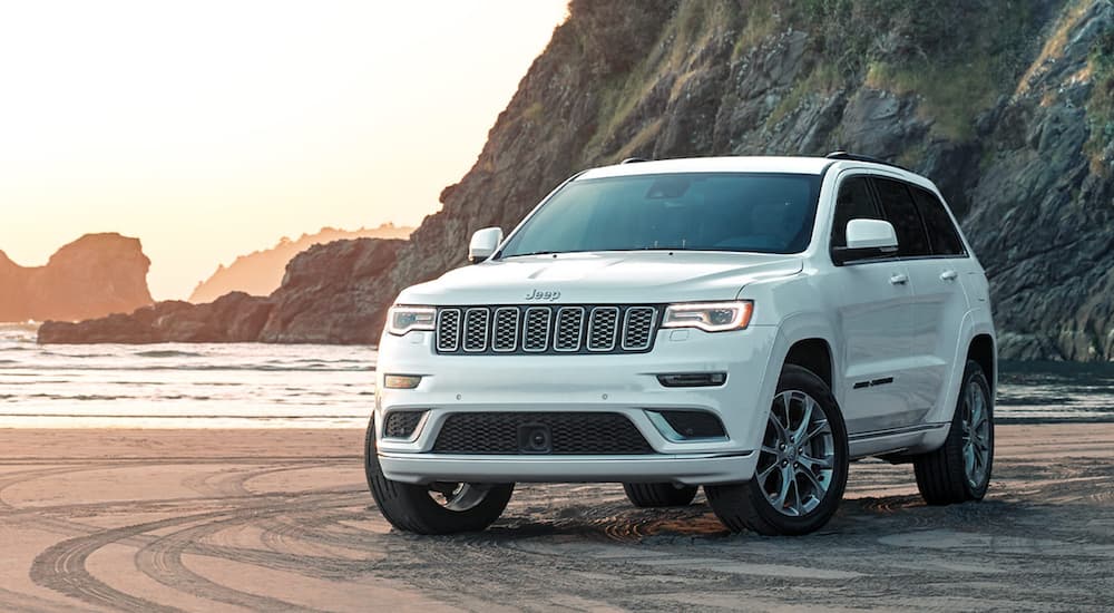 A white 2020 Jeep Grand Cherokee angled left and parked off-road.