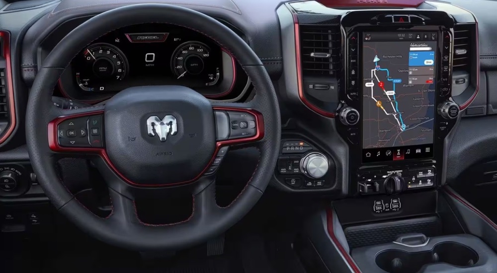 The steering wheel and infotainment screen in a used 2024 Ram 1500 Rebel for sale.