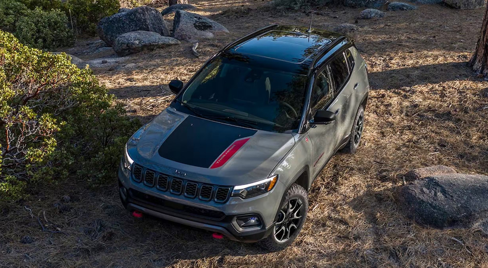 Overhead view of a grey 2024 Jeep Compass Trailhawk driving through the woods.