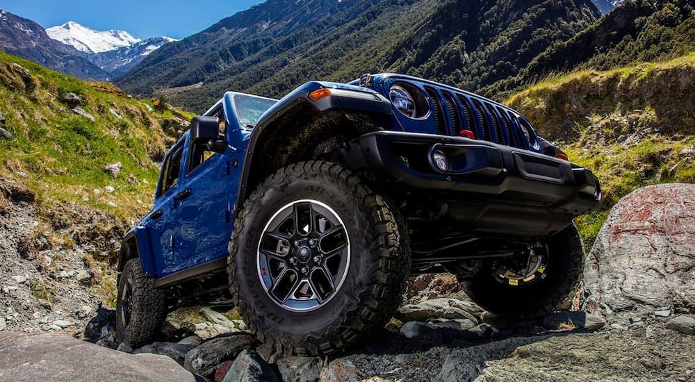 Low angle view of a blue 2019 Jeep Wrangler Rubicon parked off-road.