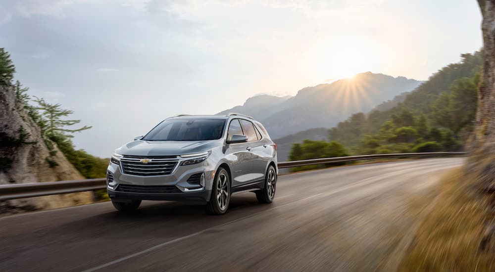 A grey 2022 Chevy Equinox Premier driving on a mountain road.