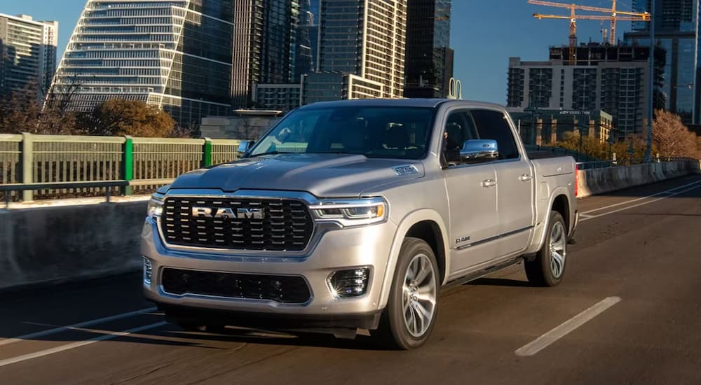 A grey 2025 Ram 1500 Tungsten driving in a city.