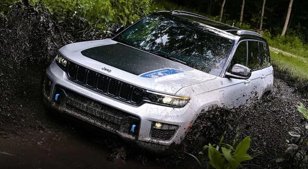 A white 2025 Jeep Grand Cherokee 4xe Trailhawk is shown from the front at an angle.