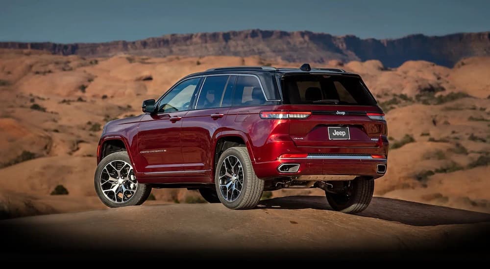 A red 2025 Jeep Grand Cherokee from the rear at an angle.