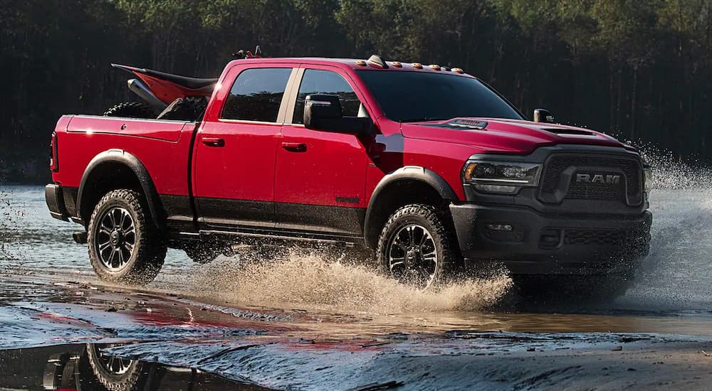 Red 2023 Ram 2500 Rebel driving through a river.