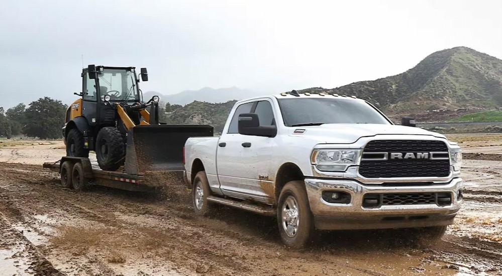 A white 2024 Ram 2500 Tradesman towing a trailer.