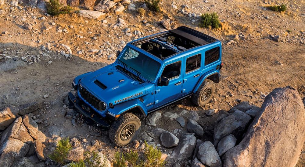 Blue 2024 Jeep Wrangler Rubicon 392 driving on a trail