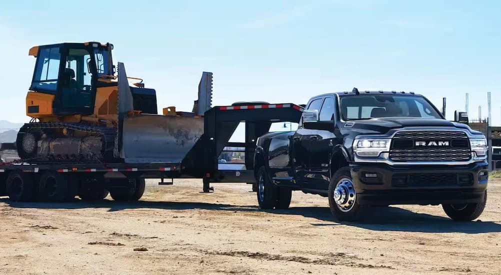 A black 2024 Ram 3500 towing a trailer.