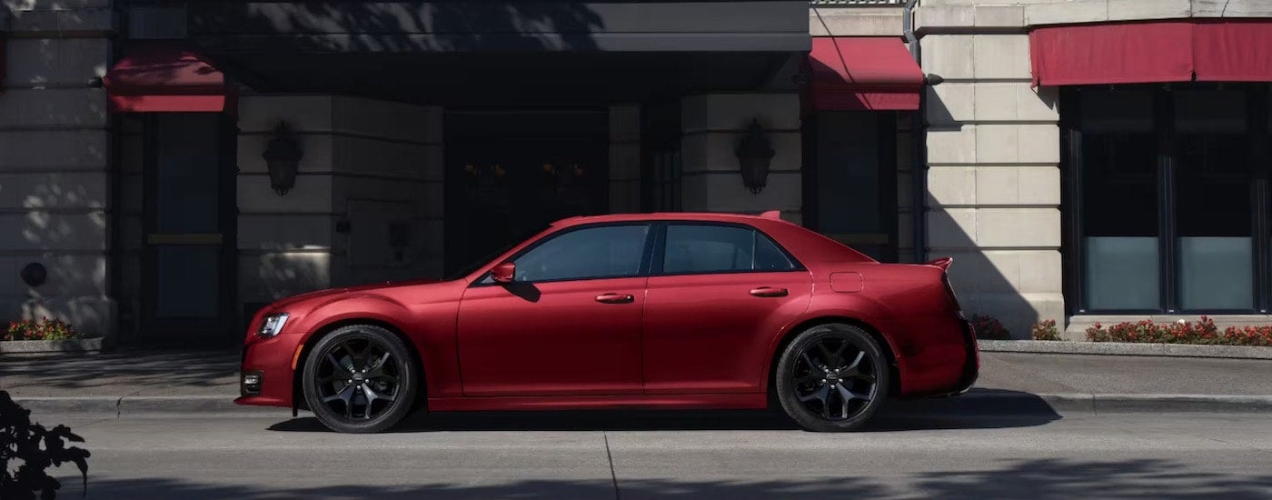 A side view of a red 2023 Chrysler 300S Hemi parked after leaving a Chrysler dealer.