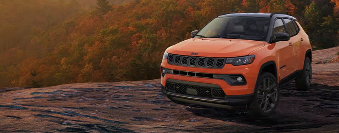 An orange 2024 Jeep Compass from the front.