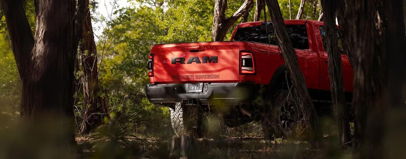 A red 2023 Ram 2500 Power Wagon parked on a trail in the woods.