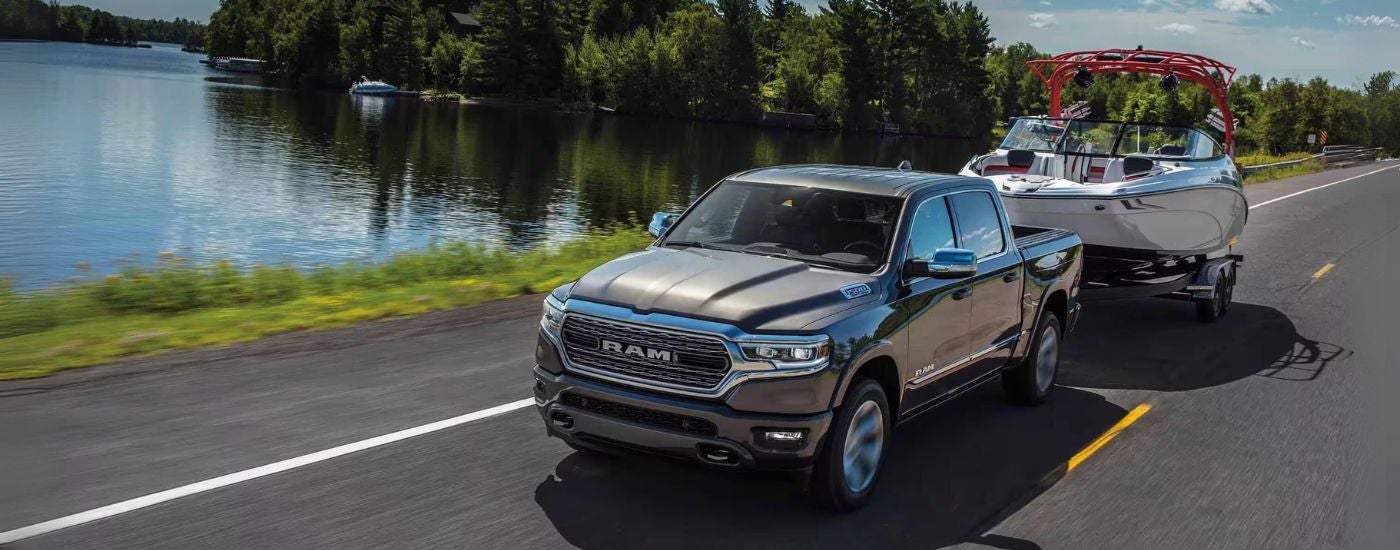 A grey 2024 Ram 1500 towing a boat after visiting a Ram dealer near Newark.