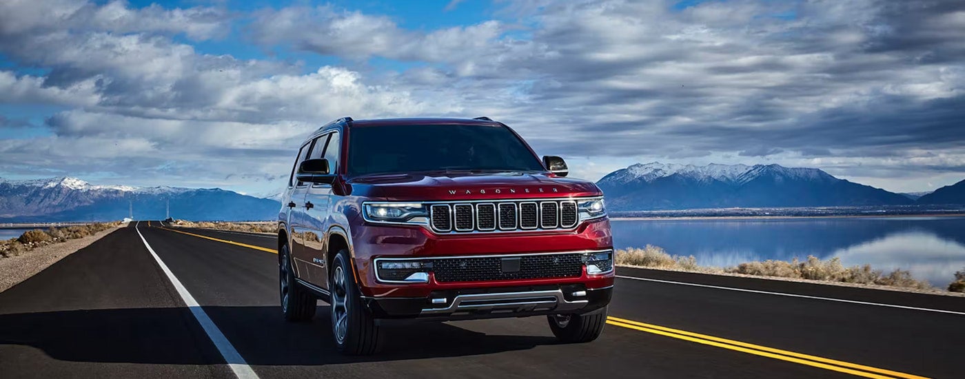 Head-on view of a red 2023 Jeep Wagoneer driving to a used car dealership near Heath.