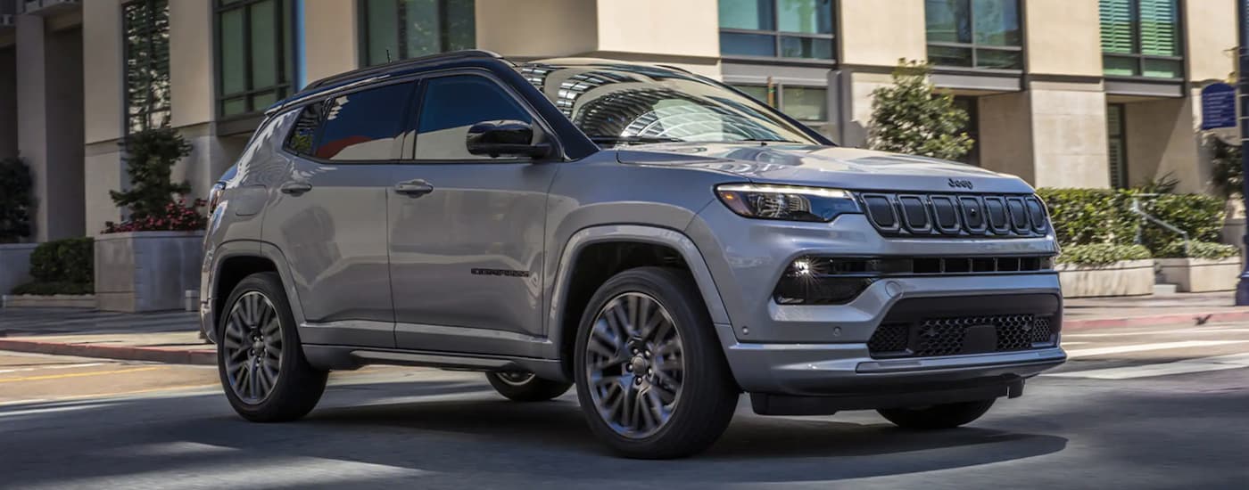 A grey 2022 Jeep Compass driving to a used car dealership near Lancaster.