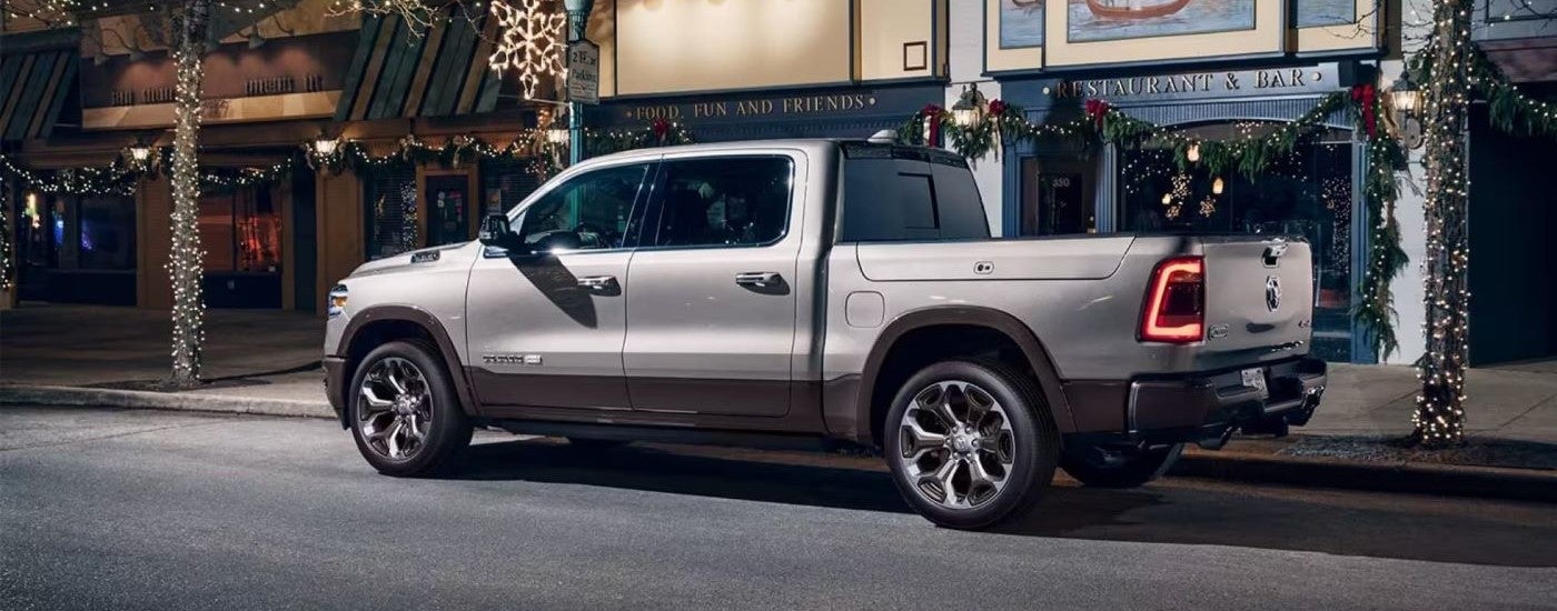 Rear view of a grey 2020 Ram 1500 parked by a city curb.
