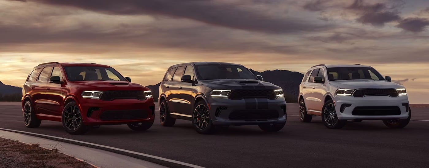 A red, a grey, and a white 2024 Dodge Durango parked next to each other.